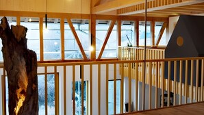 A spacious interior with wooden floors and a large tree trunk sculpture.