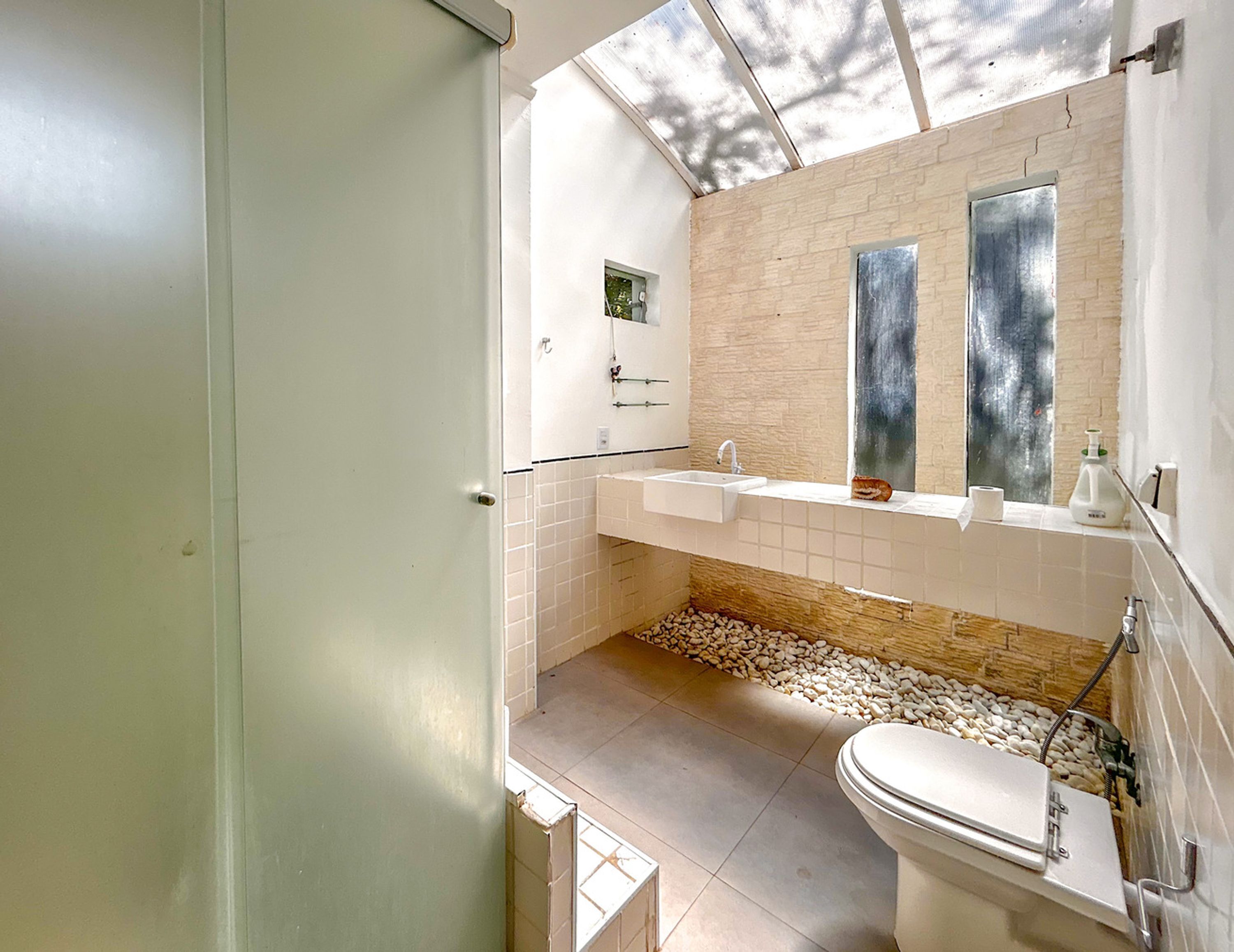 Une salle de bain moderne avec un lavabo blanc, des toilettes et un grand miroir.