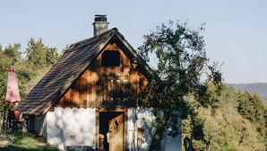Un rustico chalet in legno con tetto spiovente, un camino e una porta che dà all'interno.