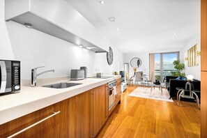 A modern kitchen with a built-in oven, a sink, and a coffee maker.