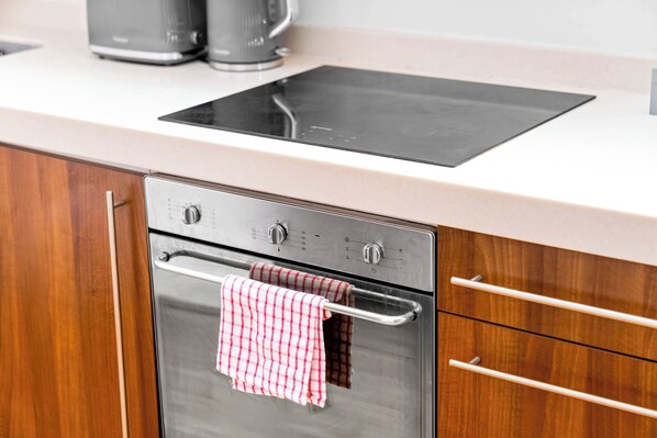 A kitchen with a built-in oven, a microwave, and a stainless steel range hood.