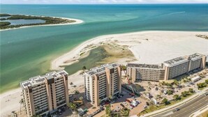 A coastal hotel with multiple high-rise buildings, a sandy beach, and a clear view of the ocean.