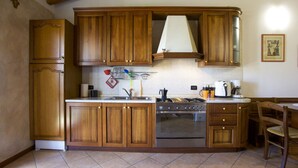Une cuisine avec des meubles de rangement en bois, une cuisinière et un évier.