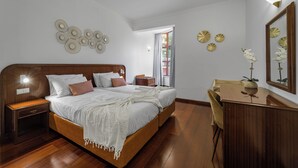 Une chambre à coucher avec un lit en bois, une table de chevet, un bureau et une chaise.