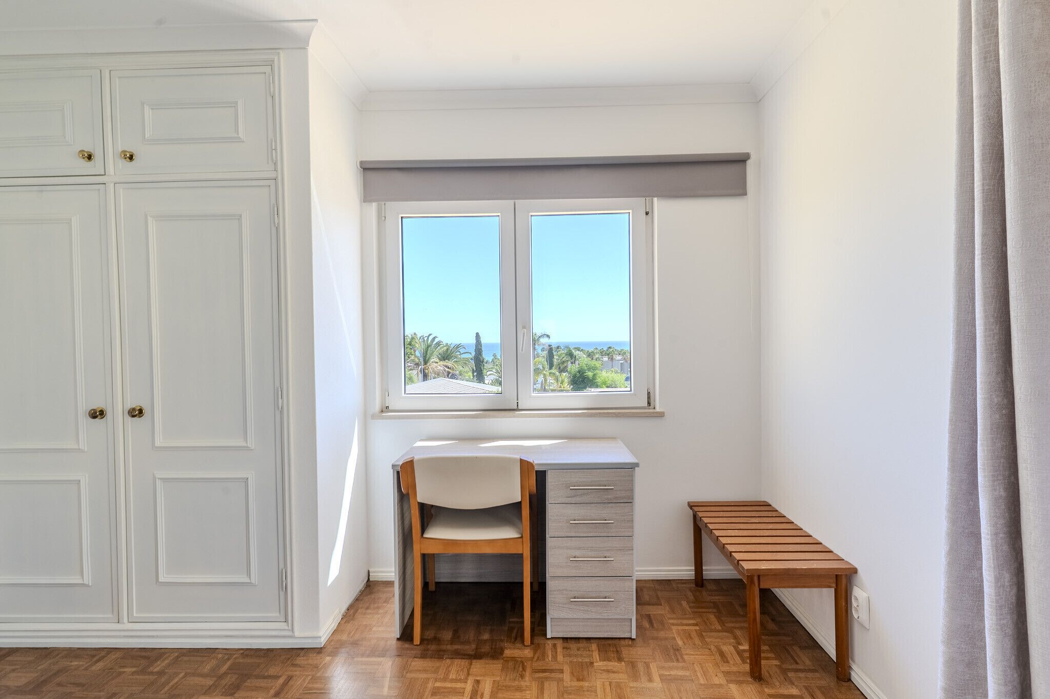 Une pièce comprenant un bureau, une chaise et une fenêtre donnant sur un paysage.