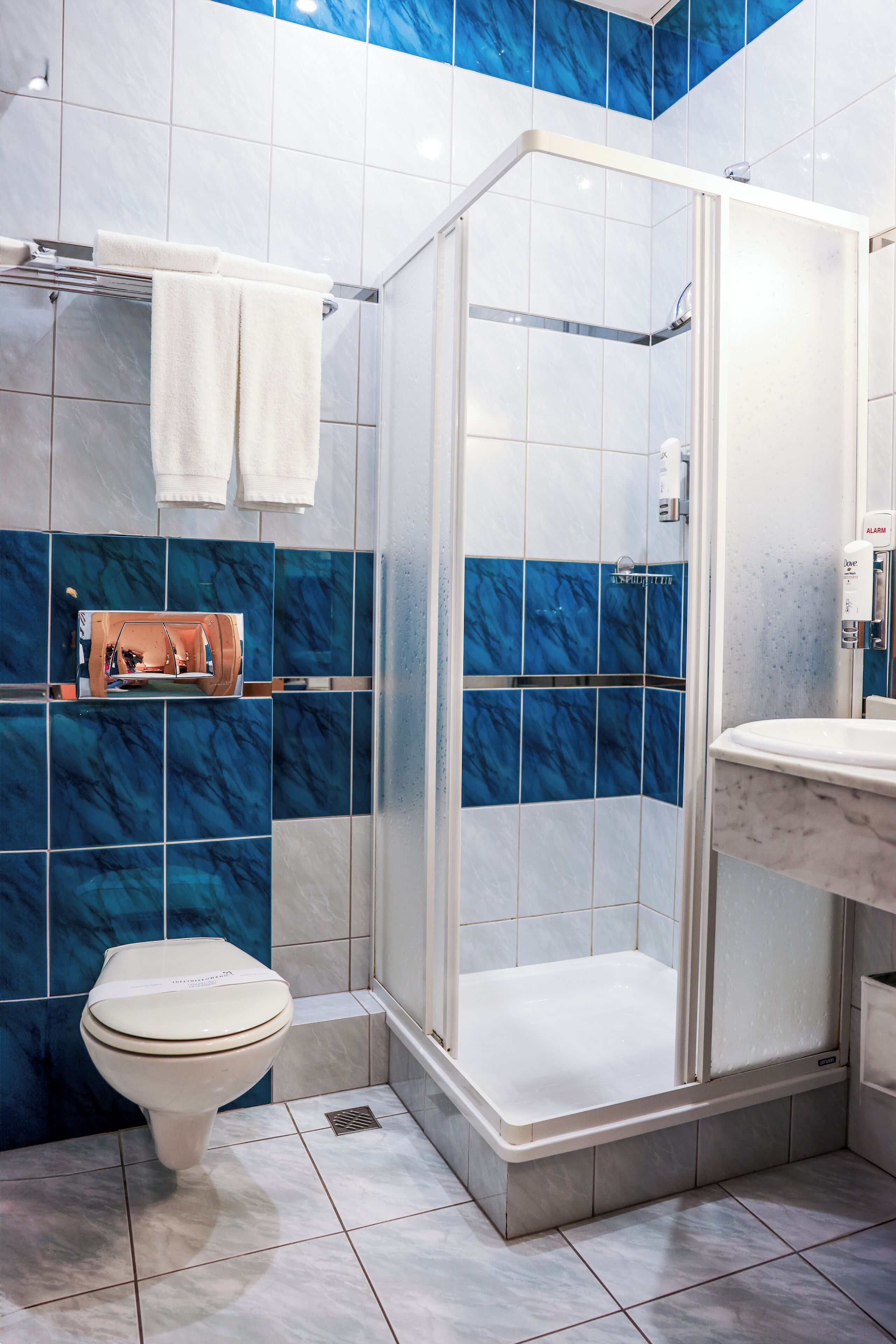Un bagno con doccia, WC e lavandino.
