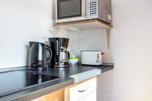 A kitchen with a microwave, coffee maker, toaster, and a bowl on the countertop. - Apartment "Apartment in Hannover Mitte" with Wi-Fi (Hannover)