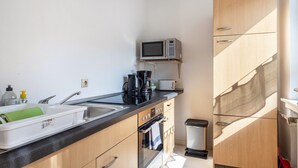A compact kitchen with a microwave, coffee maker, and a sink. - Apartment "Apartment in Hannover Mitte" with Wi-Fi (Hannover)