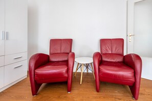 A room with two red leather chairs, a small white table, and a white wardrobe. - Apartment "Apartment in Hannover Mitte" with Wi-Fi (Hannover)