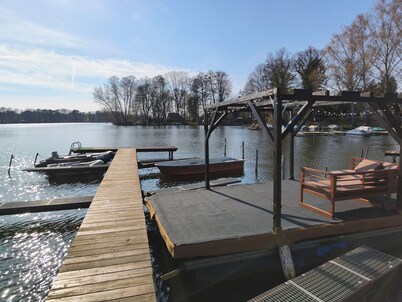 Tiny house with outdoor chimney and an own water jetty at the lakeside.