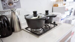 Una cuina moderna amb fogó a gas, dues paperteres elèctriques i una cafetera.