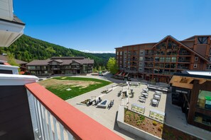 A hotel with a courtyard, outdoor seating, and a mountain backdrop. - Selkirk Bungalow - Sleeps 8 Family-Friendly Suite (Sandpoint)