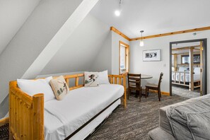 A cozy room with a wooden bed, a small table, and a chair.