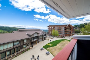 A building with a flat roof, large windows, and a paved courtyard with outdoor seating.
