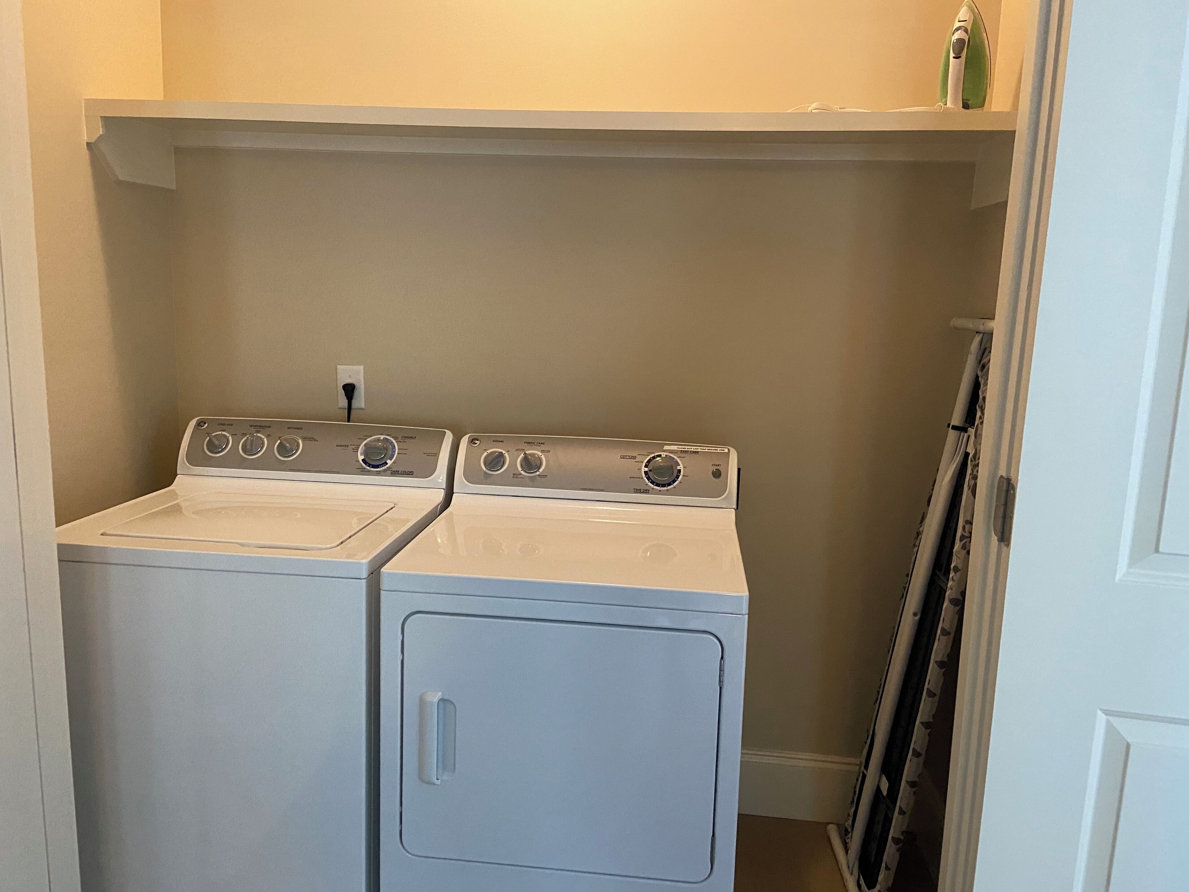 A laundry room with two front-loading washers and a dryer.