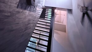 Un interior moderno con una escalera, una zona de estar y vistas a otra habitación.