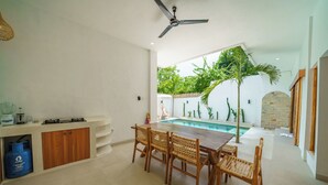 A modern kitchen with a dining area, a ceiling fan, and a poolside view. - Exclusive Villa with Breathtaking Views, Bali Villa 2180 (Bali)