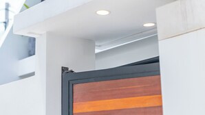 Un bâtiment moderne doté d’une grande fenêtre en verre et d’une porte en bois.