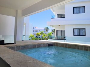Zona de piscina con vista despejada a los edificios y palmeras circundantes.