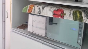 Eine Küche mit Mikrowelle, Wasserkocher und Vorratsgläsern.