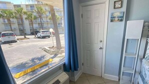 A room with a large window, a door, and a white air conditioning unit. - Charming Studio condo in excellent Daytona Beach (Daytona Beach)