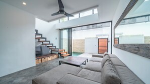 Een modern interieur met een trap, een bank en een eettafel.