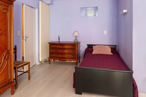 A bedroom with a bed, dresser, chair, and a radiator. - Guest Room 'Lavande 4 Persons' with Shared Pool, Shared Terrace and Wi-Fi (Segonzac)