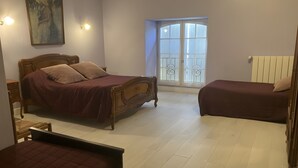 A bedroom with a large bed, a smaller bed, a chair, a desk, and a window with a view. - Guest Room 'Lavande 4 Persons' with Shared Pool, Shared Terrace and Wi-Fi (Segonzac)