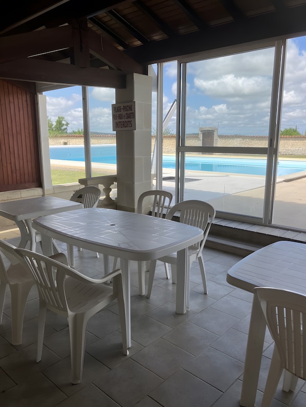 A covered patio area with a pool view, white plastic tables and chairs, and a sign indicating a plunge pool. - Bed and Breakfast 'Chambre 4 - 2 Personnes' with Shared Pool, Shared Terrace and Wi-Fi (Segonzac)