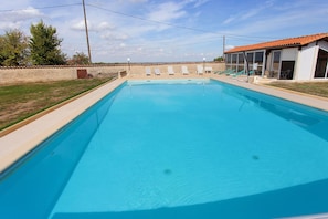 A rectangular swimming pool with clear blue water, surrounded by a low stone wall and a grassy area. - Bed and Breakfast 'Chambre 4 - 2 Personnes' with Shared Pool, Shared Terrace and Wi-Fi (Segonzac)