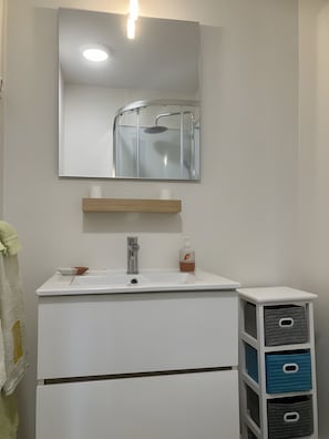 A bathroom with a white sink, a mirror above it, a towel hanging on the wall, and a small shelf with a soap dispenser. - Bed and Breakfast 'Chambre 4 - 2 Personnes' with Shared Pool, Shared Terrace and Wi-Fi (Segonzac)
