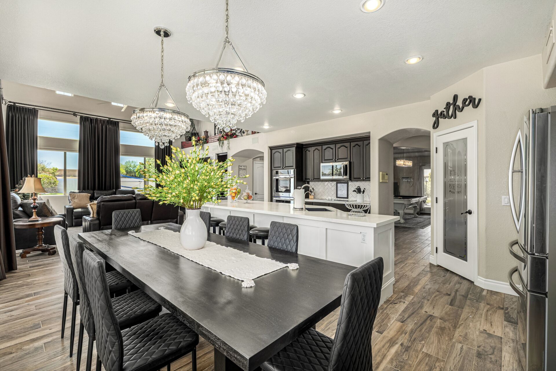 A modern kitchen with dark cabinetry, a central island, and pendant lighting.