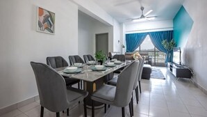 Un espace repas avec une longue table, plusieurs chaises et un ventilateur de plafond.