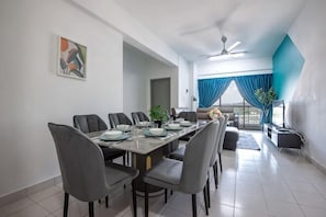 A dining area with a long table, multiple chairs, and a ceiling fan.
