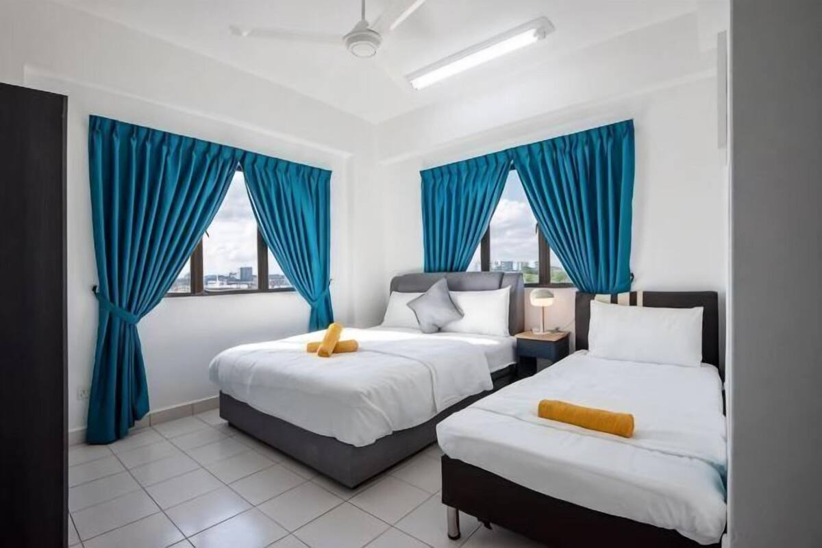 Une chambre d’hôtel avec deux lits, une table de chevet, une lampe et une vue sur la ville.