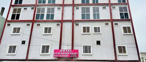A multi-story building with a sign indicating it houses a hotel and restaurant.