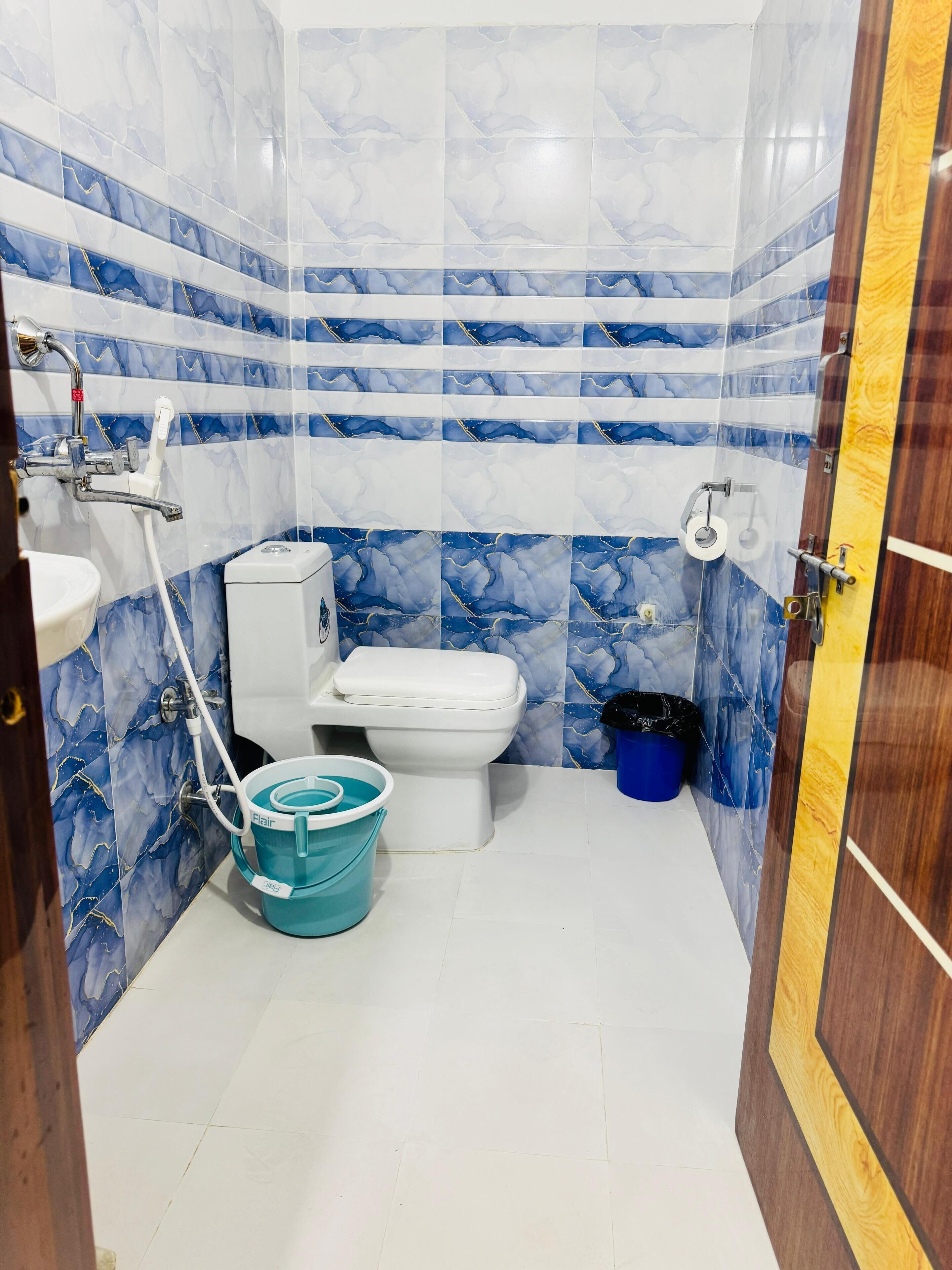 Een badkamer met toilet, douche en wastafel.