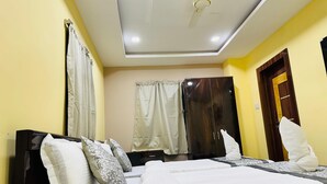 Una stanza con due letti, un ventilatore a soffitto e un armadio.