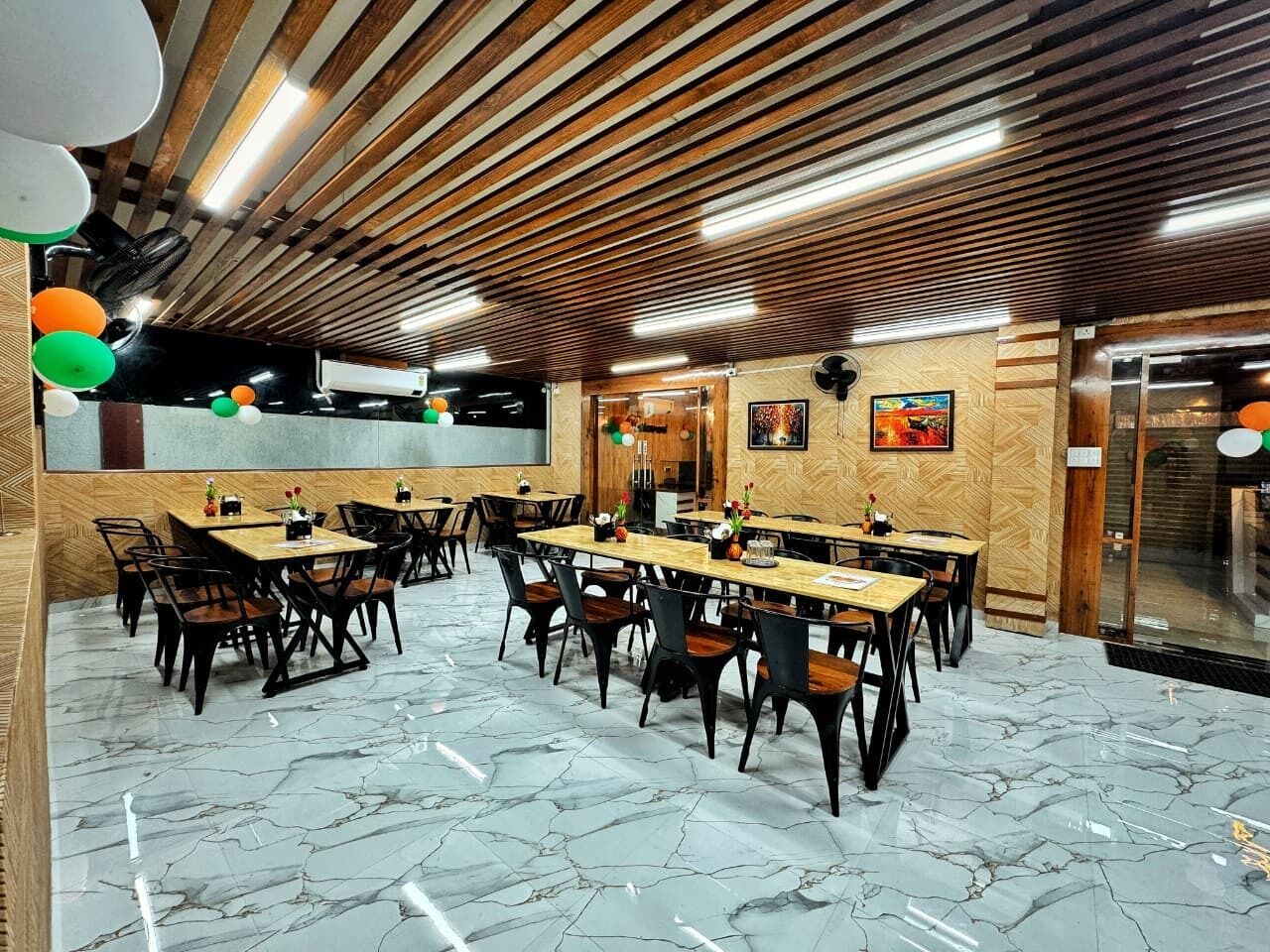Un salón de conferencias con mesas y sillas de madera, suelo de mármol y techo de madera con listones.