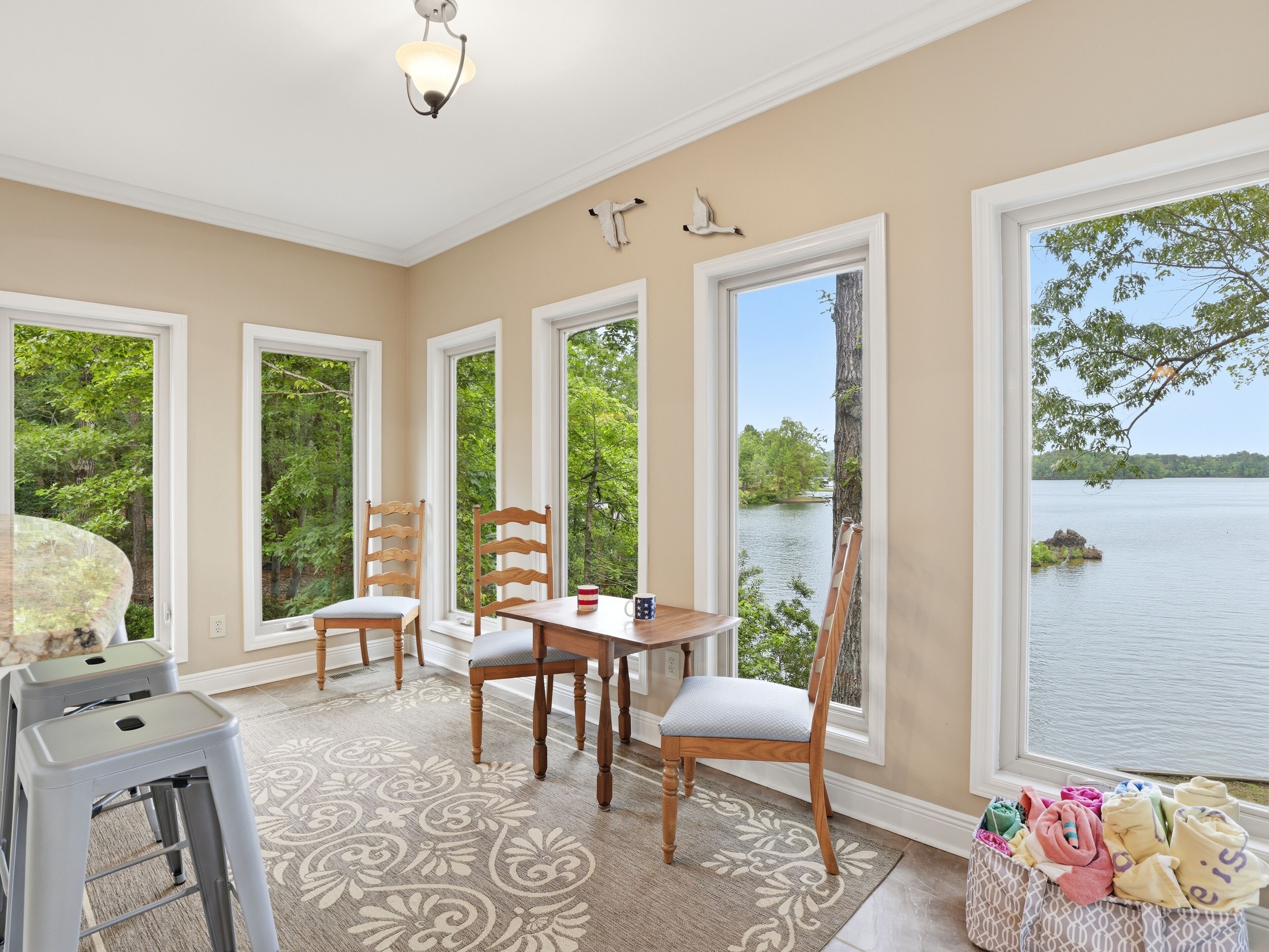 Un espace repas comprenant une table, des chaises et donnant sur un lac.