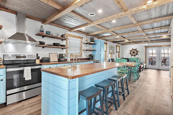 A kitchen with a central island, bar stools, and a dining area with a table and chairs. - Family Friendly 2BR townhouse nestled between sugary beaches and Destin Harbor (Destin)