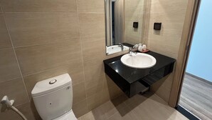 A modern bathroom with a white toilet, a black sink, and a mirror above it. - NS Home B5-301 (Phu Quoc)