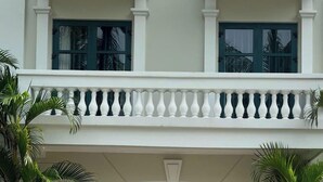 A building with a double entrance, a balcony with white balustrades, and potted plants. - NS Home B5-301 (Phu Quoc)
