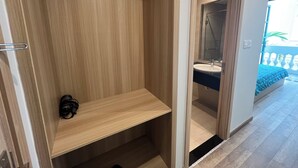 A modern bathroom with a wooden vanity, a mirror, and a shower area. - NS Home B5-301 (Phu Quoc)