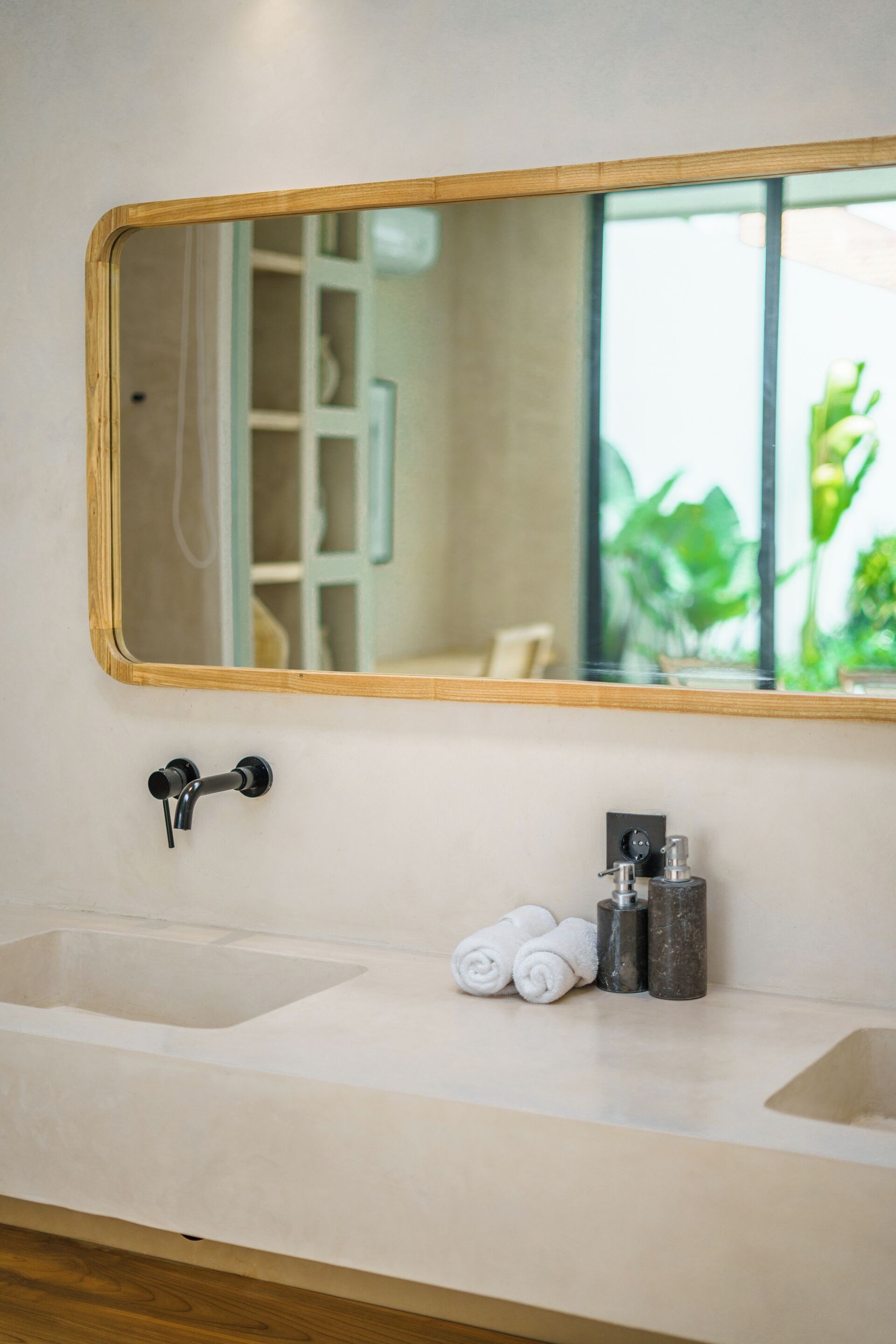 Une salle de bain avec un miroir encadré en bois, un lavabo et un porte-serviettes avec des serviettes.