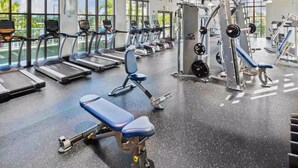 A gym with treadmills, a bench press, and weightlifting equipment.