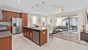 A modern kitchen with a central island, stainless steel appliances, and wooden cabinets.