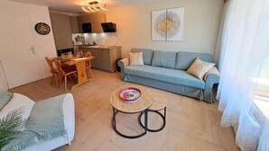 Un salon moderne avec un canapé, une table à manger et une table basse.