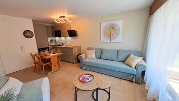 A modern living room with a sofa, a dining table, and a coffee table.