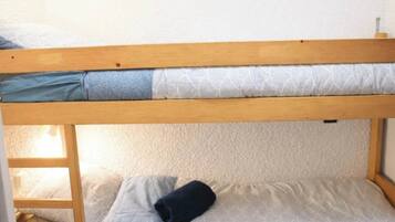 A bunk bed with a wooden frame and patterned bedding.